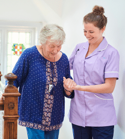 caregiver helping a senior women to walk